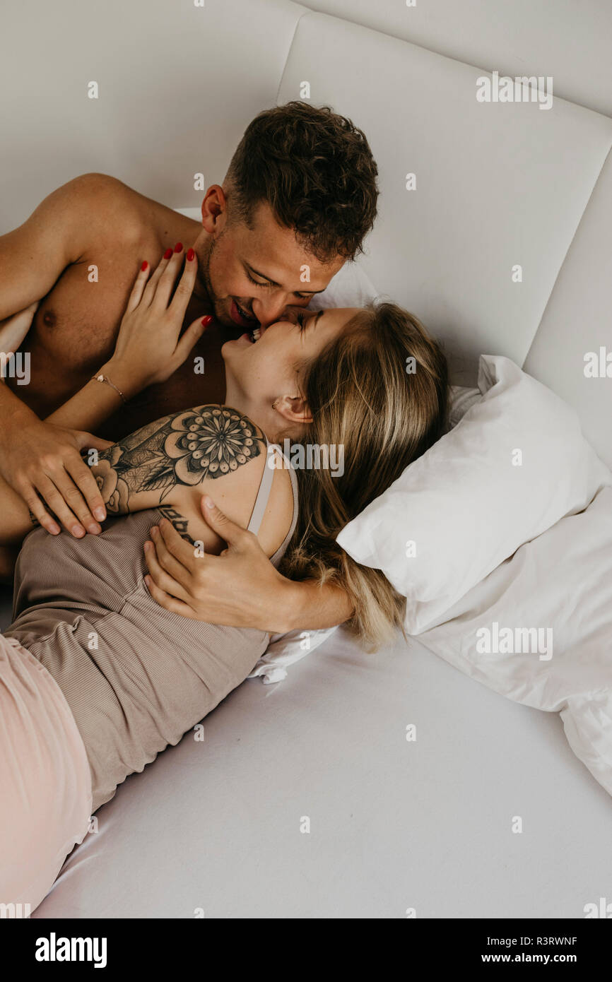 couple kissing in bed